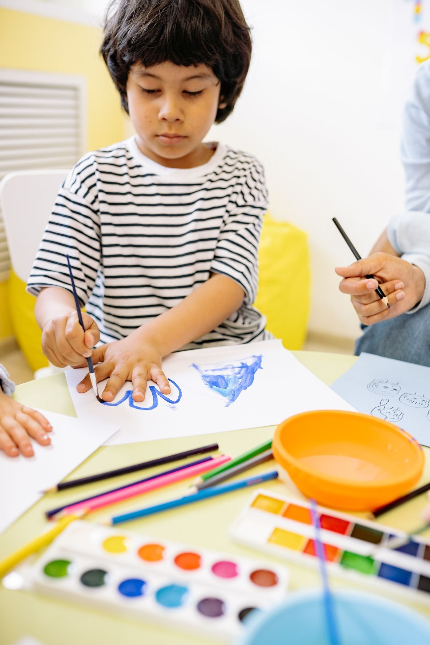 Coloured pencils and paints on a table during art-based therapy