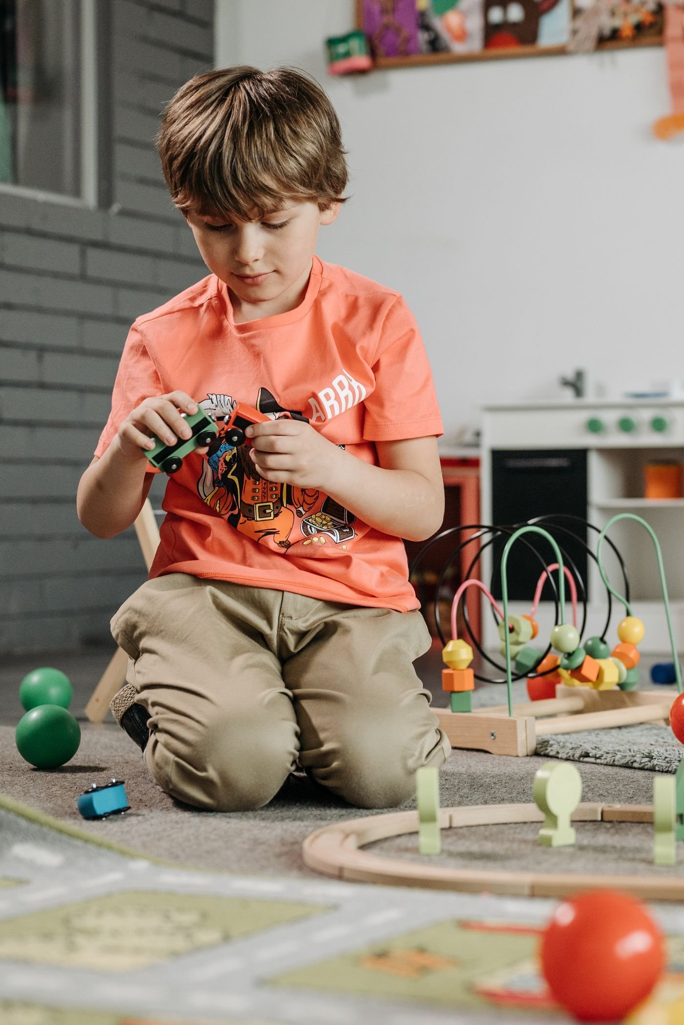 A young boy playing with a toy train set