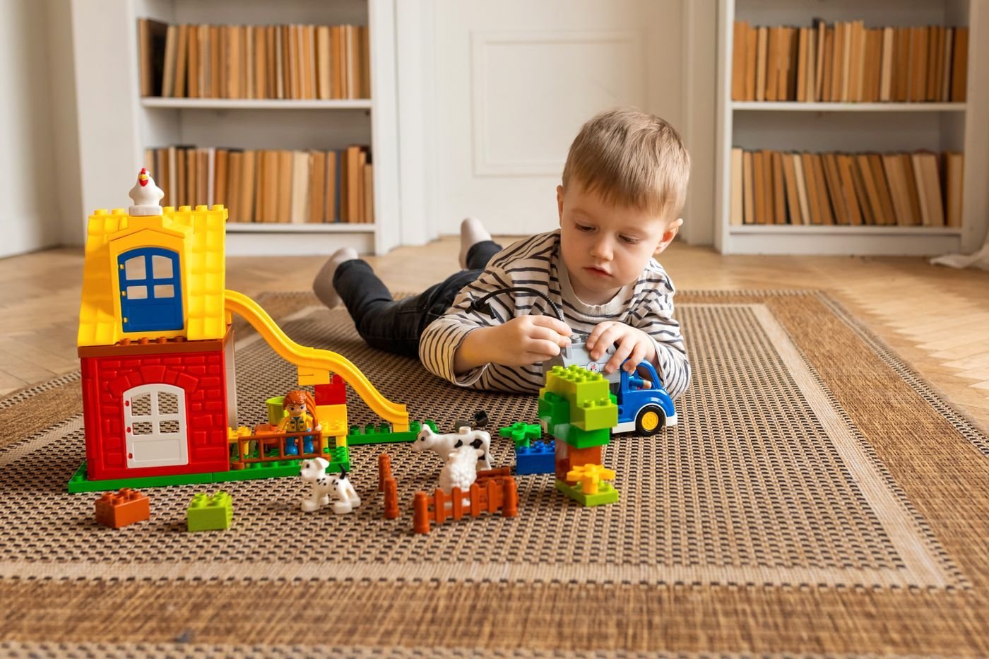 A child playing with toys on a rug