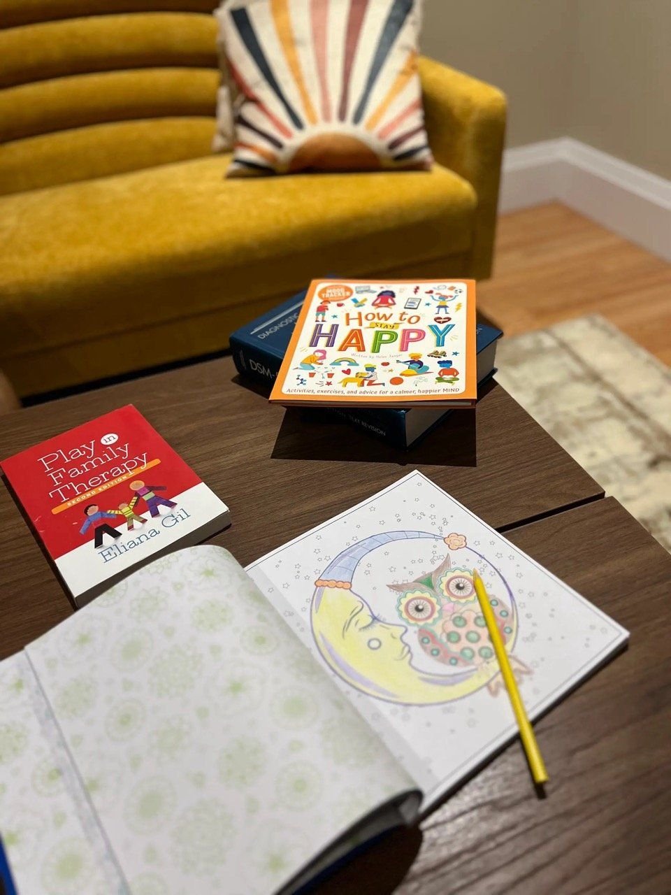 Play therapy books and a colouring page on the table