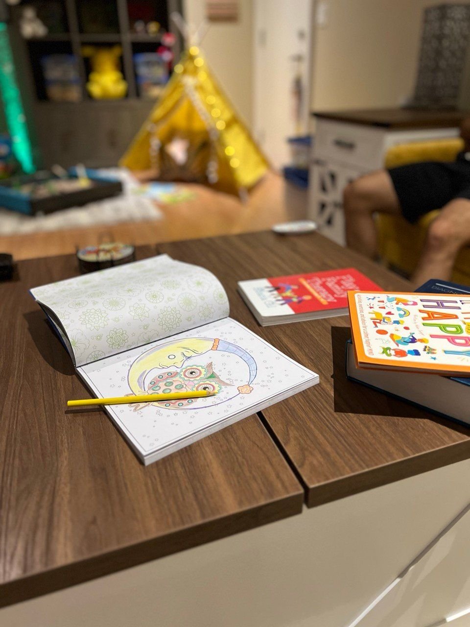 Colouring books on the table with the reading tent behind