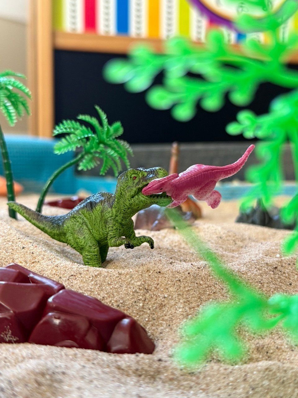 Dinosaur figures in the sand tray