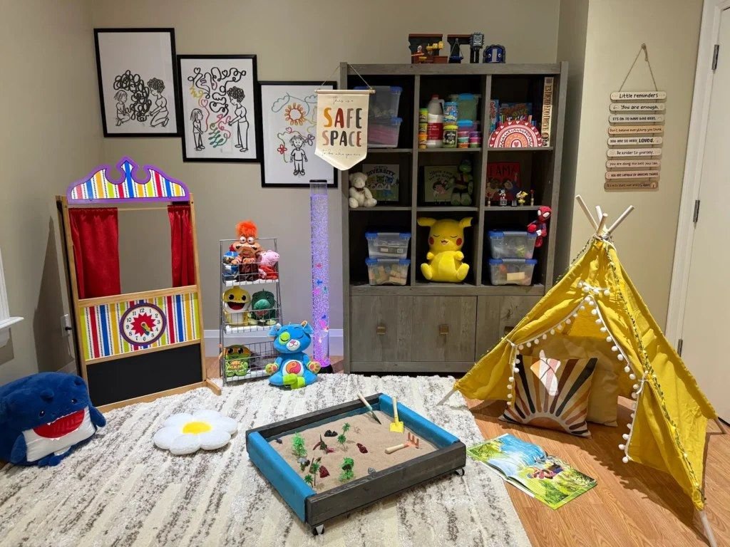 Play therapy room with a puppet theatre, toy shelves, and a reading tent