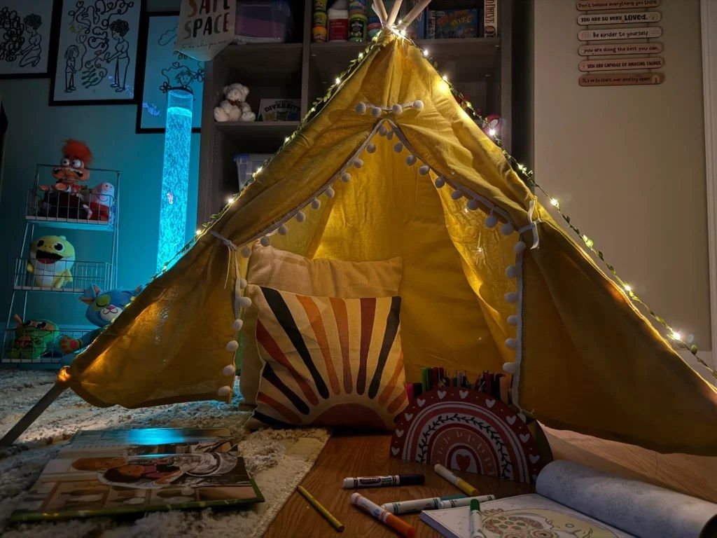 Play therapy room with a reading tent, puppet theatre, and sand tray