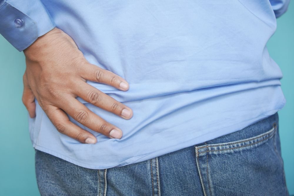 Man pressing a hand to his lower back