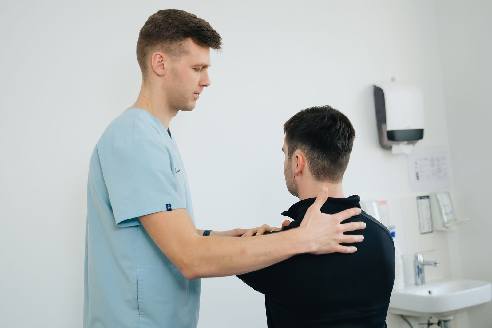 Physiotherapist assessing a patient's shoulder