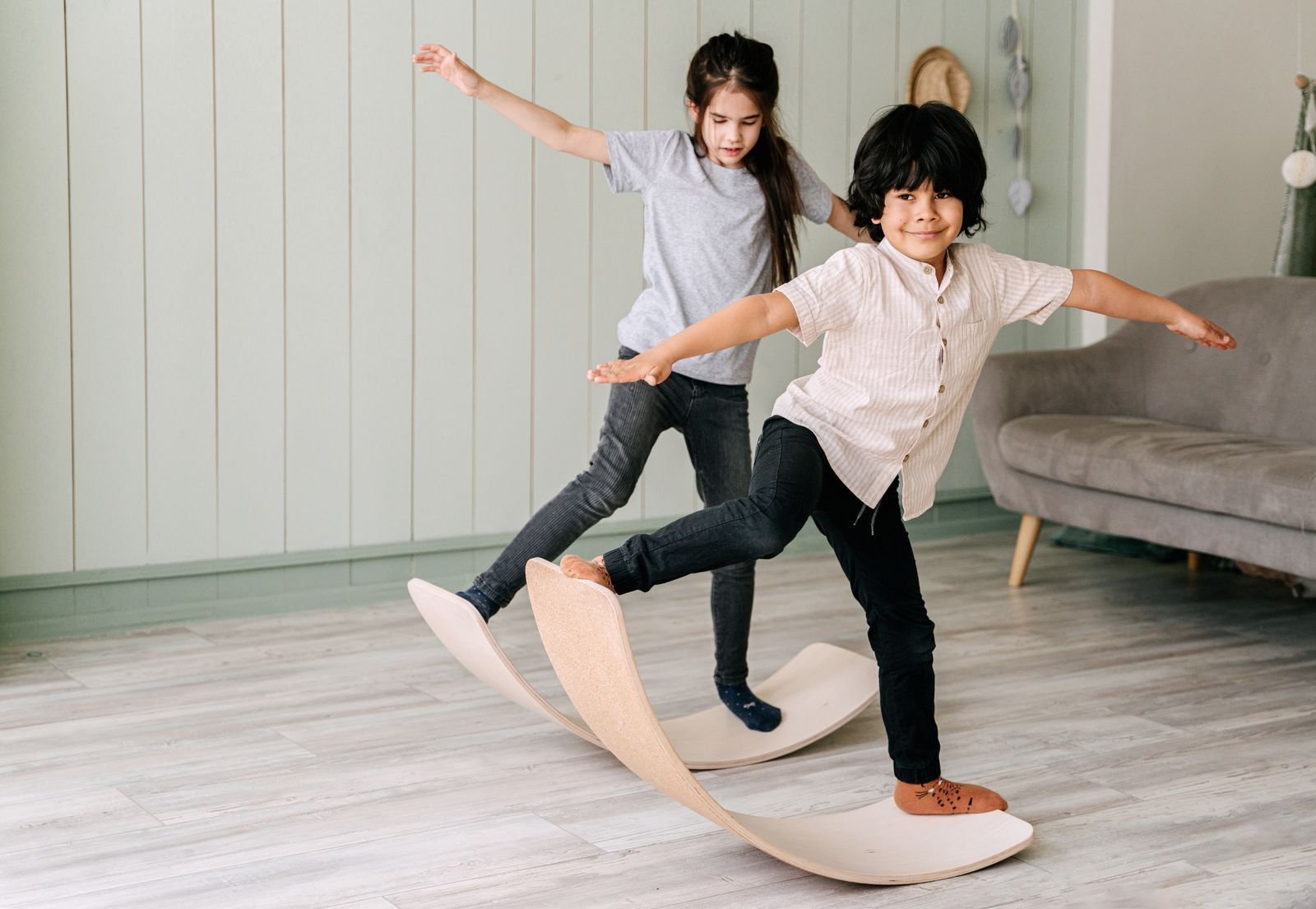 Two children balancing on a wooden balance board