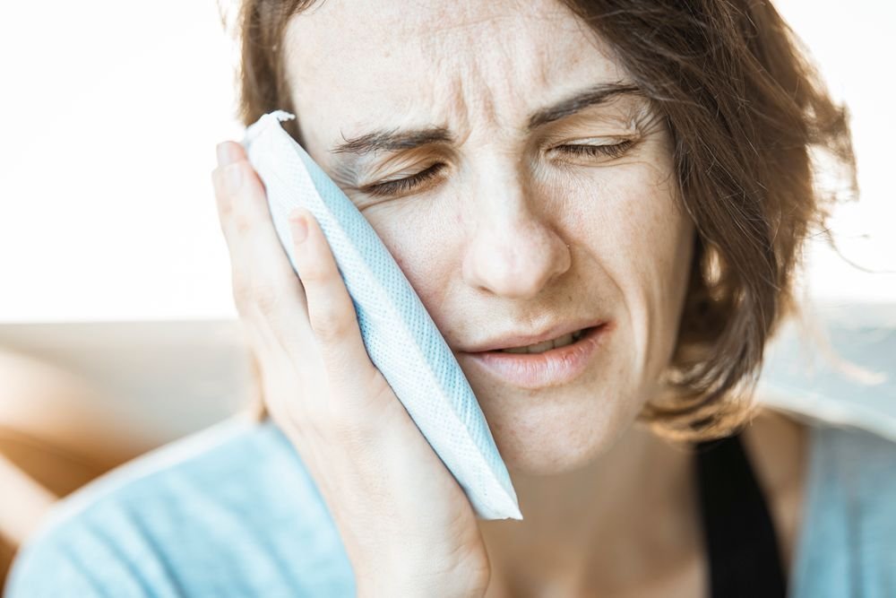 Woman holding a cold pack against her jaw