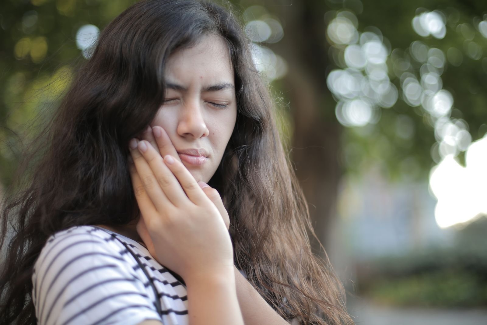 Woman holding her jaw in discomfort